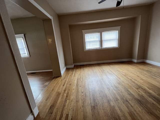 unfurnished room featuring hardwood / wood-style flooring, baseboards, and ceiling fan