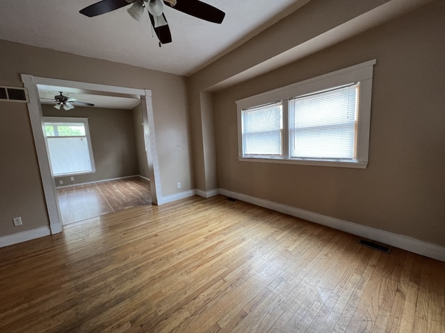 unfurnished room with visible vents, baseboards, ceiling fan, and wood-type flooring