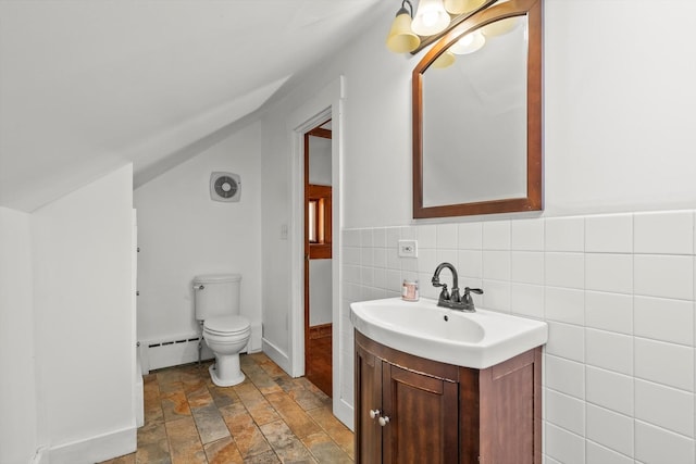 bathroom with tile walls, toilet, lofted ceiling, vanity, and a baseboard radiator