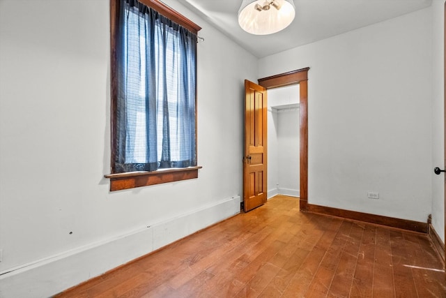 unfurnished room with wood finished floors, baseboards, and a wealth of natural light