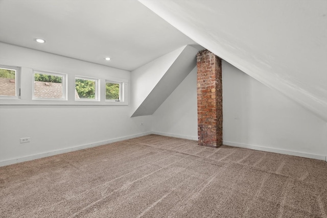 additional living space with baseboards, lofted ceiling, and carpet floors