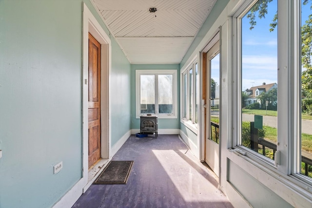 unfurnished sunroom with a wood stove