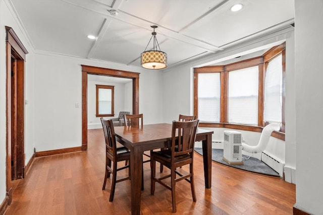 dining space with a healthy amount of sunlight, coffered ceiling, and wood finished floors