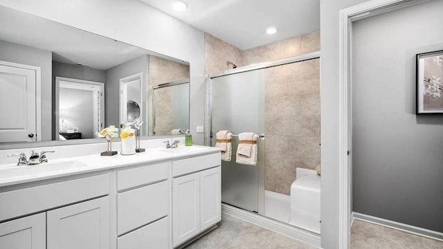 bathroom featuring a sink, double vanity, a shower stall, and tile patterned floors