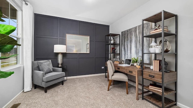 office area featuring light carpet, a decorative wall, baseboards, and visible vents