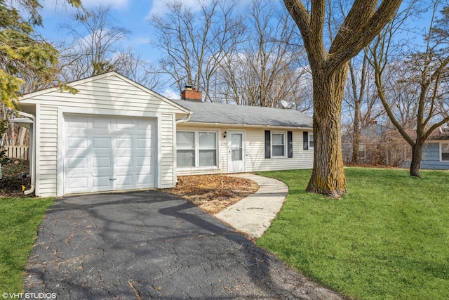 ranch-style home featuring a front lawn, roof with shingles, a chimney, driveway, and an attached garage