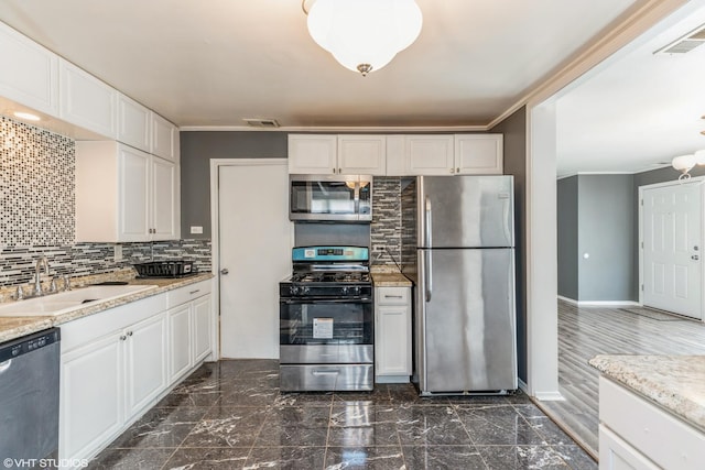 kitchen with visible vents, ornamental molding, a sink, tasteful backsplash, and appliances with stainless steel finishes