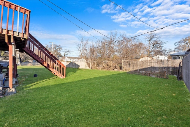 view of yard featuring a wooden deck, stairs, and a fenced backyard