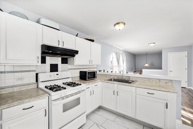 kitchen featuring a peninsula, a sink, white gas range oven, under cabinet range hood, and stainless steel microwave