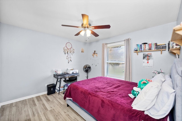 bedroom with a ceiling fan, wood finished floors, and baseboards