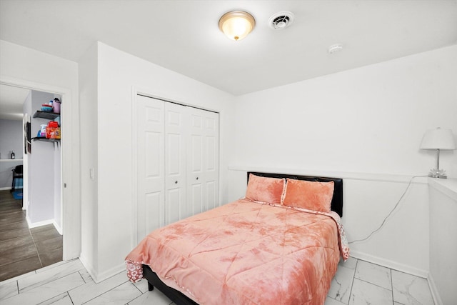 bedroom with a closet, baseboards, visible vents, and marble finish floor