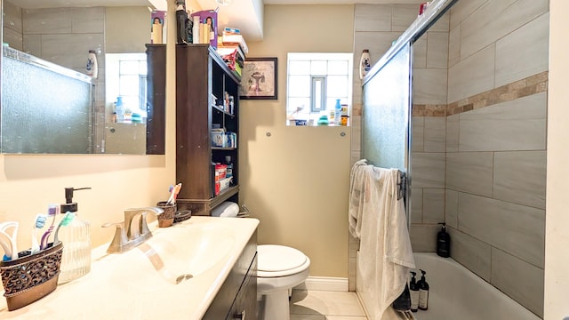 bathroom featuring enclosed tub / shower combo, a healthy amount of sunlight, toilet, and vanity