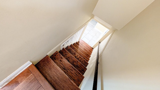 stairway featuring baseboards and wood finished floors