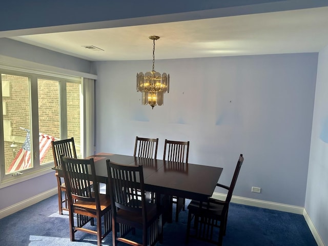 dining room featuring dark colored carpet, visible vents, baseboards, and a chandelier