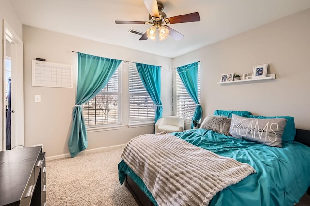 carpeted bedroom with visible vents, baseboards, and ceiling fan