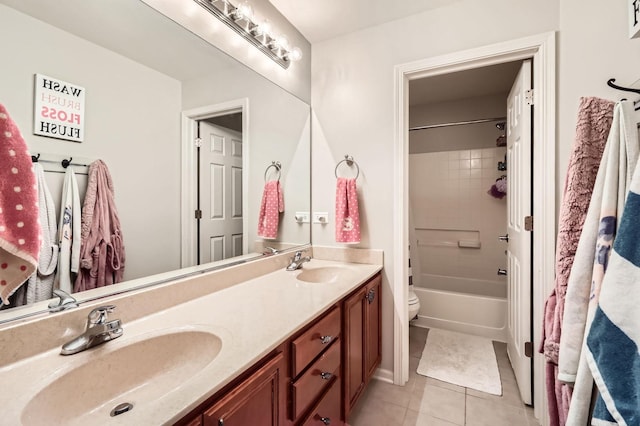 full bathroom with a sink, toilet, double vanity, and tile patterned floors