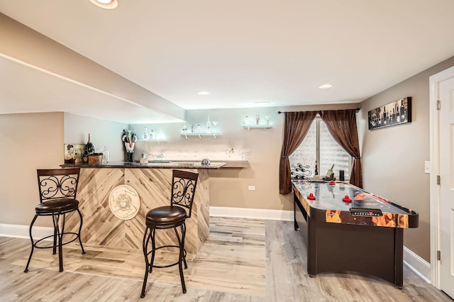 bar with recessed lighting, baseboards, bar area, and light wood-style flooring