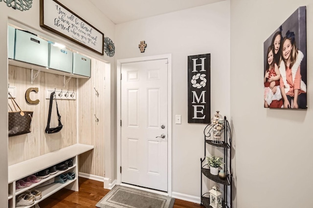 mudroom featuring dark wood-type flooring and baseboards