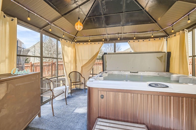 view of patio / terrace featuring an indoor hot tub and fence