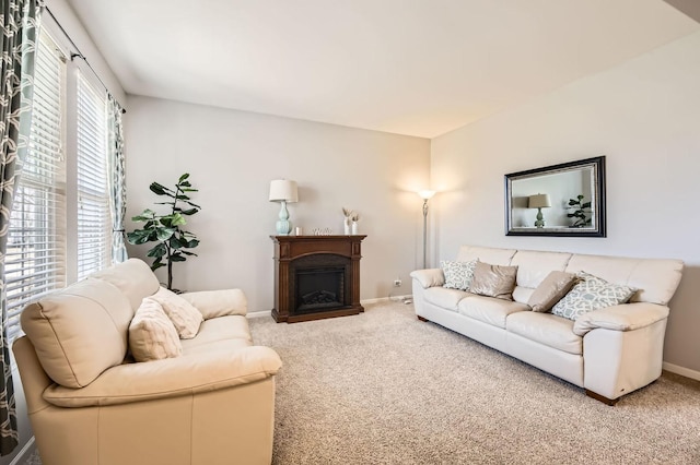 living area featuring a fireplace, carpet, and baseboards