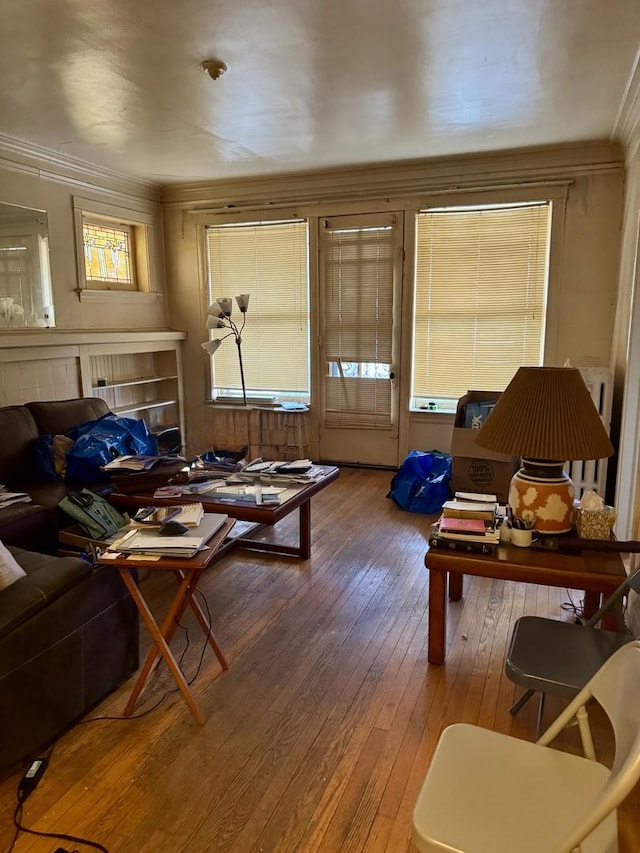 living area featuring hardwood / wood-style floors and crown molding