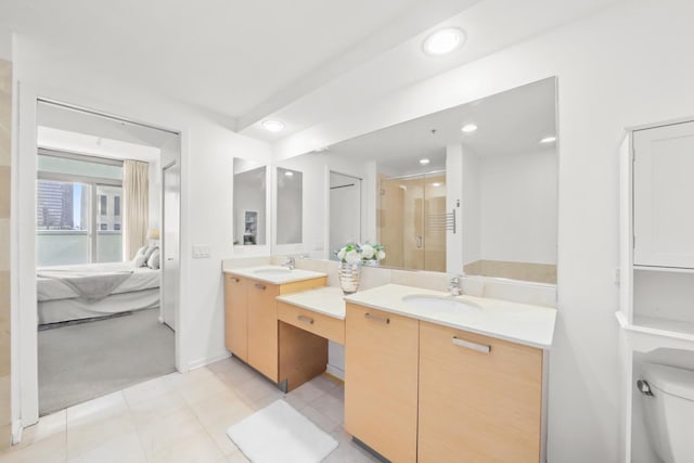 bathroom featuring a sink, two vanities, a shower stall, and ensuite bathroom