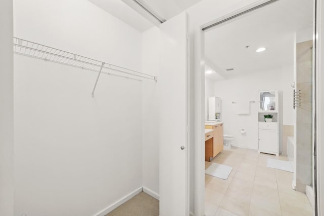 walk in closet with light tile patterned floors