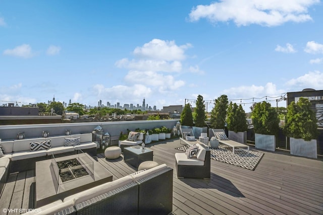 wooden deck featuring a view of city and an outdoor living space with a fire pit