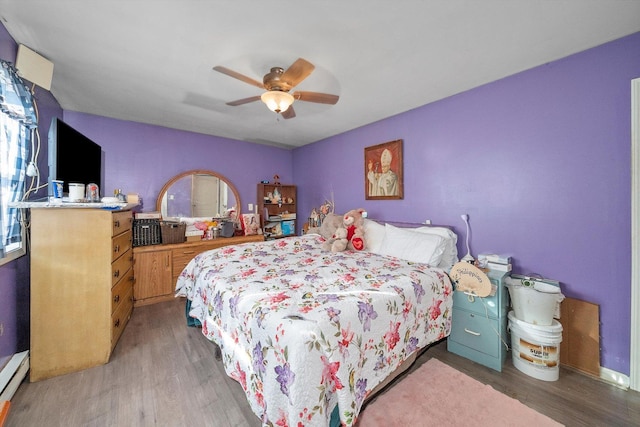 8325 S Dante Ave, Chicago, IL 60619 - bedroom with a baseboard heating unit, a ceiling fan, multiple windows, and wood finished floors