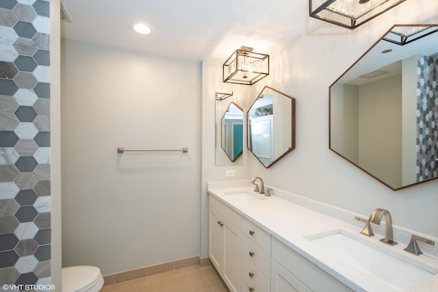 full bathroom with double vanity, toilet, tile patterned floors, and a sink