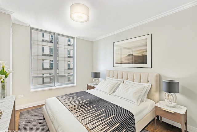 bedroom with crown molding, wood finished floors, and baseboards