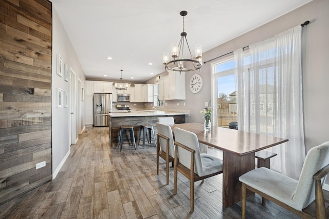 dining room featuring recessed lighting, baseboards, an inviting chandelier, and wood finished floors