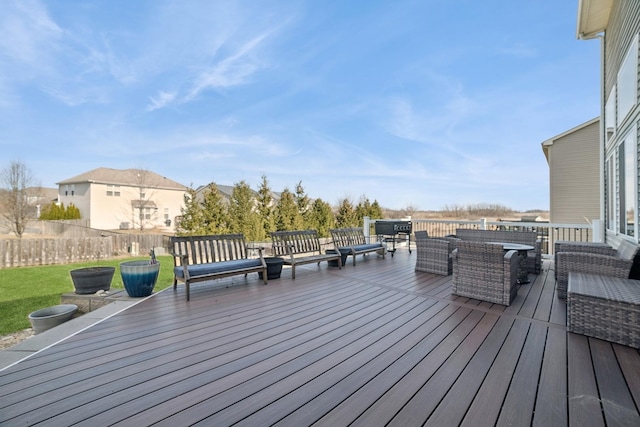 deck with outdoor dining space, a lawn, outdoor lounge area, and fence