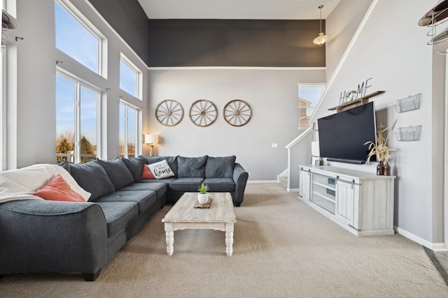 living room with stairway, a high ceiling, carpet flooring, and baseboards