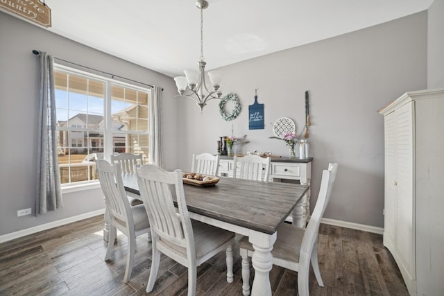 dining area featuring baseboards, an inviting chandelier, and wood finished floors