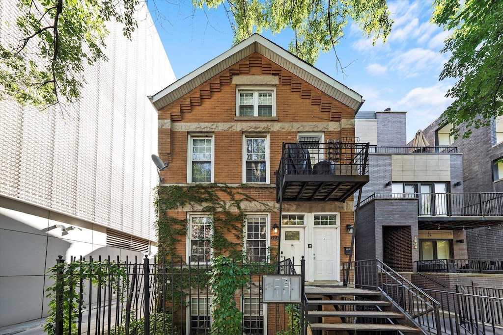1545 N Bosworth Ave Unit 1W, Chicago, IL 60642 - view of front of house with brick siding and a fenced front yard