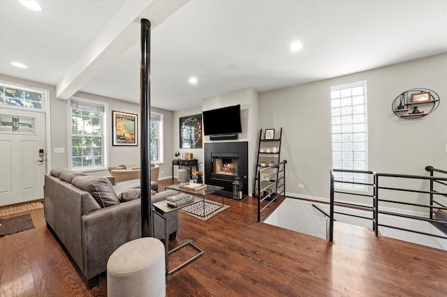 living room with baseboards, a fireplace with flush hearth, beam ceiling, recessed lighting, and wood finished floors