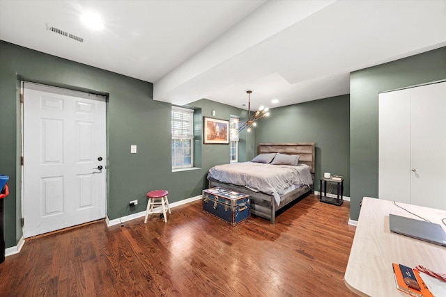 bedroom with visible vents, baseboards, and wood finished floors