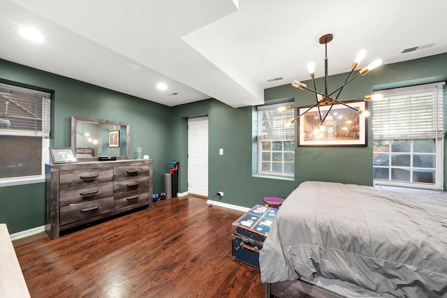 bedroom featuring visible vents, multiple windows, baseboards, and wood finished floors