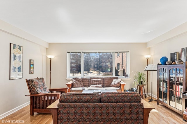 living area featuring baseboards and light wood-style floors