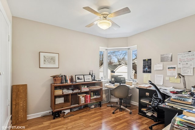 office featuring baseboards, a ceiling fan, and wood finished floors