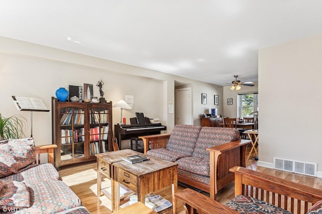 living area featuring visible vents, a ceiling fan, and light wood-style floors