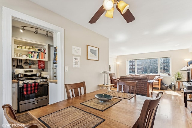 dining space with a ceiling fan and wood finished floors