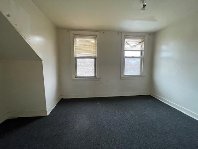 interior space with dark carpet and baseboards