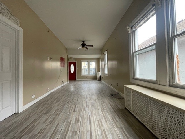 foyer with radiator, wood finished floors, baseboards, and ceiling fan