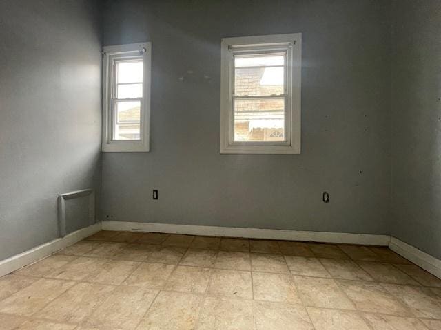 unfurnished room with visible vents and baseboards