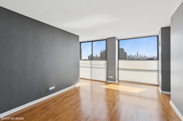 345 W Fullerton Pkwy Unit 1006, Chicago, IL 60614 - unfurnished room featuring a view of city, wood-type flooring, and baseboards