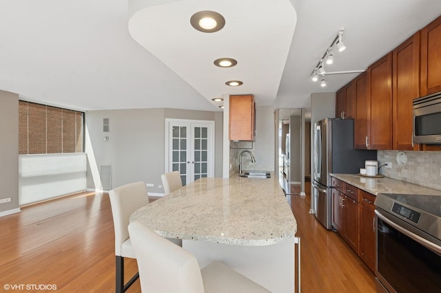 345 W Fullerton Pkwy Unit 1006, Chicago, IL 60614 - kitchen featuring a kitchen bar, tasteful backsplash, a peninsula, appliances with stainless steel finishes, and a sink