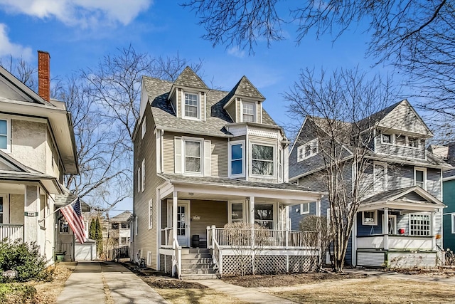 view of front of house featuring concrete driveway, covered porch, and roof with shingles