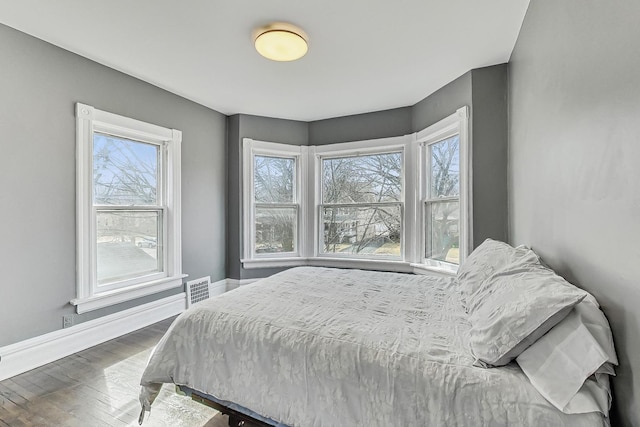 bedroom featuring visible vents, baseboards, and wood finished floors